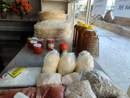 Tezgâhta yufka destesi, ev salçası kavanozları ve zeytinyağı